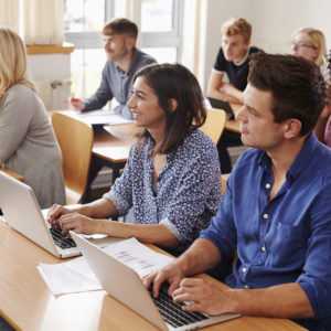 Mature Students Sitting At Desks In Adult Education Class for six sigma